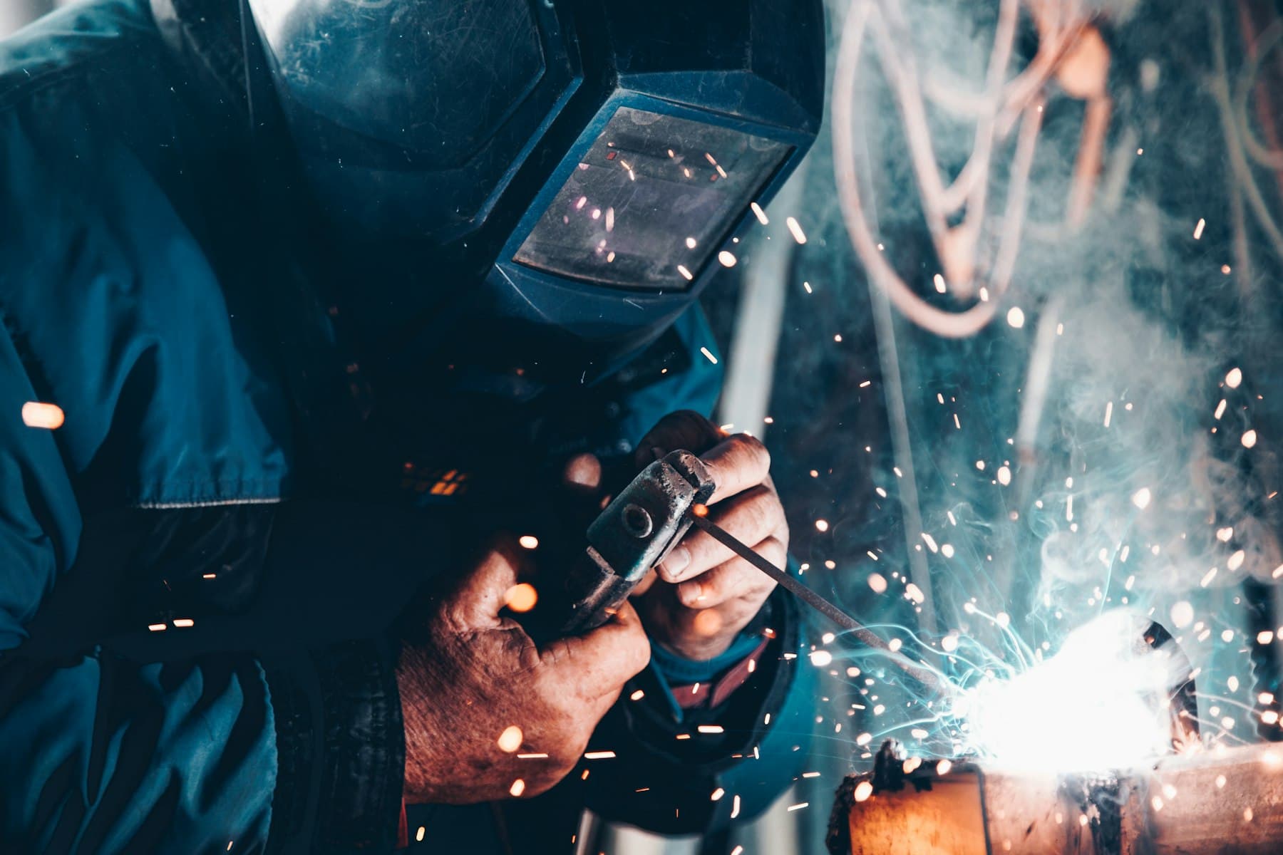 Welder working on steel fabrication amid sparks